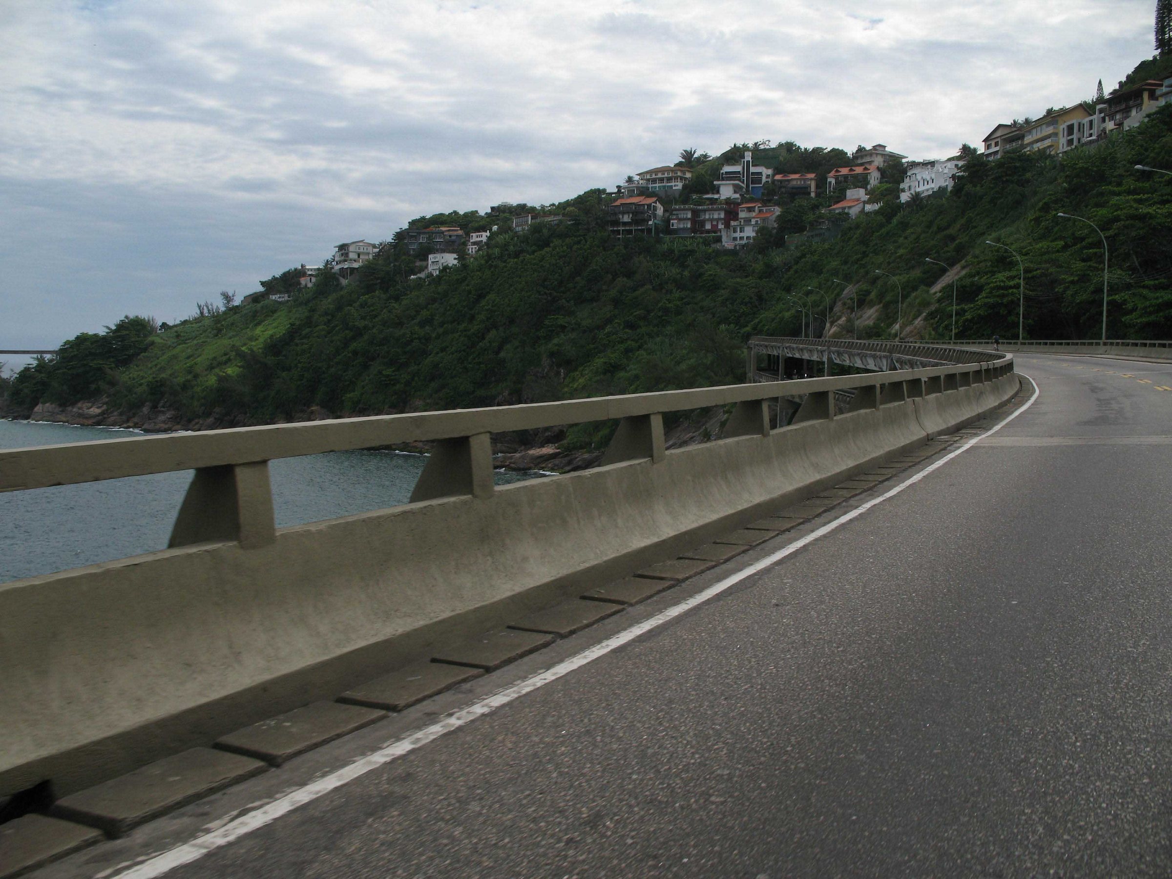 The Elevado do Joá — the elevated coast road that threads the cliffs between São Conrado and Barra, with Joá's houses on the hill above.