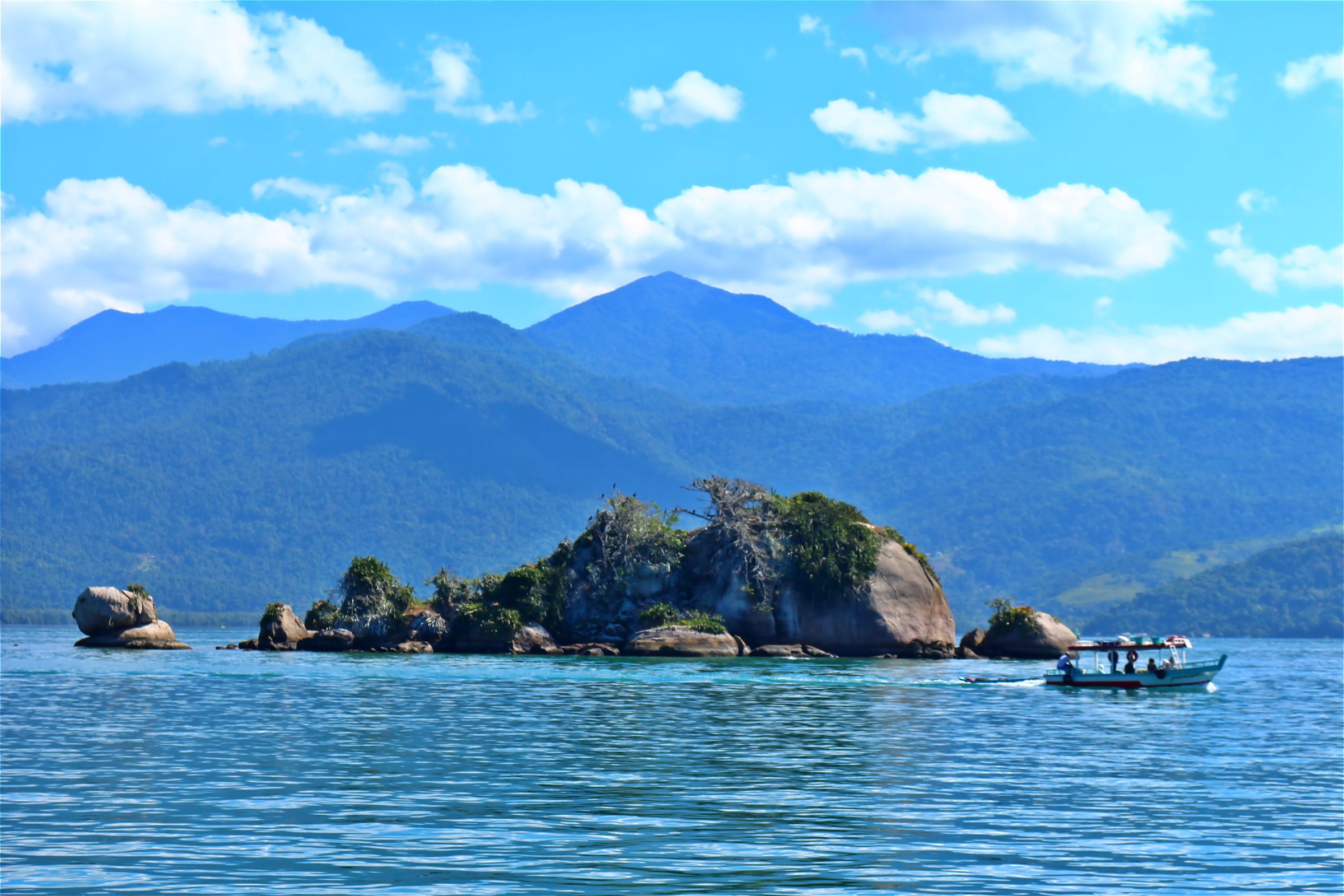 Ilhas na baía de Paraty, com as montanhas verdes da Costa Verde ao fundo.